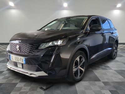 la voiture noire est garée sur un sol en damier dans le garage