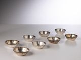 six silver bowls are arranged in a row on a white surface