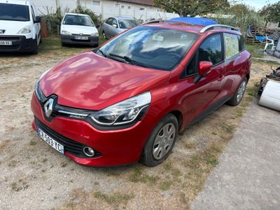La voiture rouge est garée sur le parking, à côté d'autres voitures.
