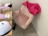 a pink chair sitting next to a table with a pink shirt on it