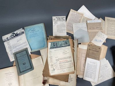 une pile de vieux papiers et de vieux livres posée sur une table