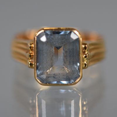 une image d'une bague en or avec une pierre en topaze bleue