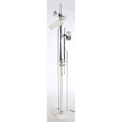 a metal floor lamp with a white base and a light on top of it