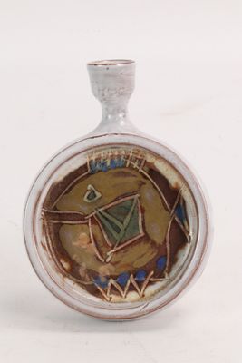 une photo d'une bouteille en verre ornée d'un motif