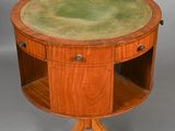 a round table with a green leather top on a wooden stand