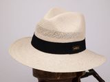 Le chapeau est blanc et noir, avec un ruban noir.