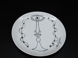 a white plate with a drawing of a candle on it