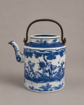 blue and white teapot with a handle on a gray background