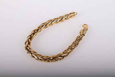 un bracelet en or avec un motif de tresse sur fond blanc