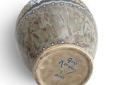 a brown vase with writing on it on a white surface