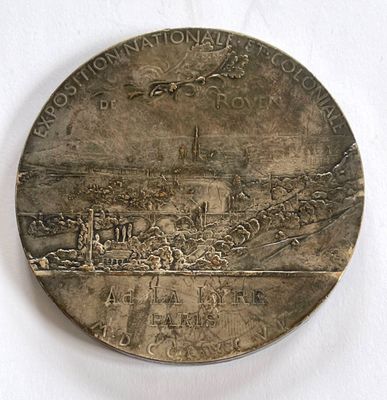 une médaille d'argent sur laquelle est représentée une ville
