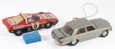 deux voitures jouets assises l'une à côté de l'autre sur une surface blanche