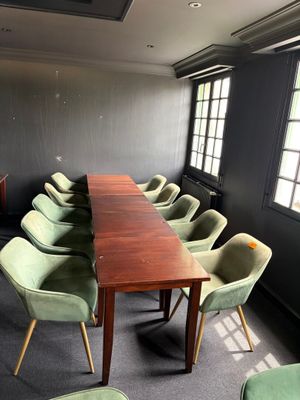une longue table entourée de nombreuses chaises dans une pièce