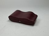 a brown leather case with a small hole in the middle