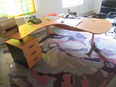 a desk with a computer on top of it in a room