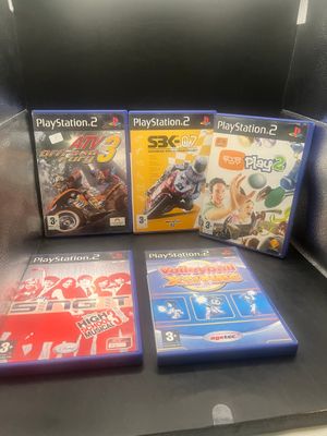 trois jeux vidéo posés sur la table, dans la boîte