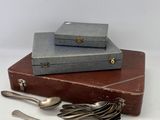 une pile de couverts posée sur une valise