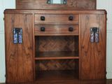 a wooden cabinet with a mirror on top of it