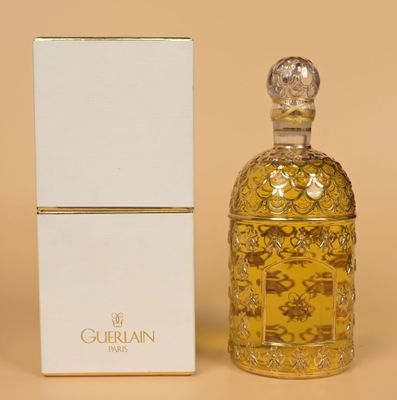 a bottle of perfume next to a box on a table