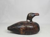 a close up of a wooden duck on a white surface
