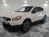 la voiture blanche est garée sur un sol en damier dans le garage