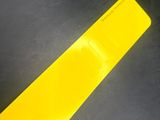 a yellow strip on the floor of a parking lot