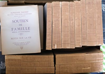 plusieurs cartons de livres empilés les uns sur les autres sur une table