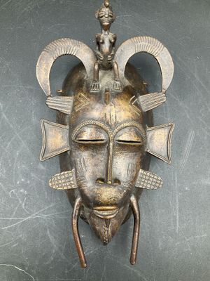 an image of a metal mask hanging on the wall of a room