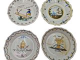 quatre assiettes à motifs différents sur une surface blanche