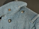 a blue coat with buttons on it on a mannequin head