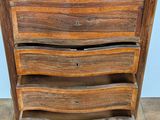 a wooden chest of drawers on a tile floor
