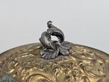 a silver plate with a bird on top of it
