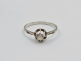 a silver ring with a white diamond in the center
