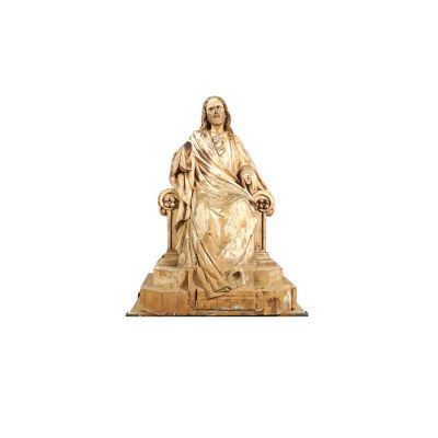 statue of jesus sitting on a throne with a cross in his hand