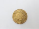 a close up of a gold coin on a white surface