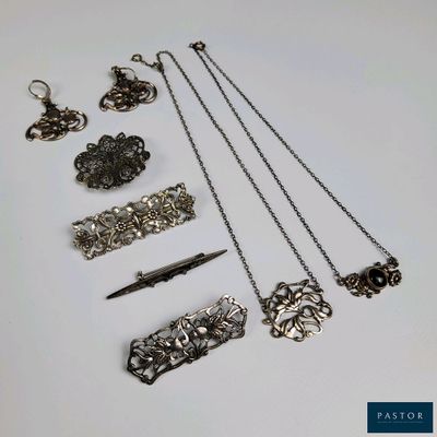 a lot of silver jewelry on a white table