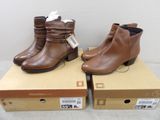 pair of women ' s brown leather ankle boots on top of boxes