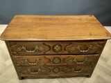 an old wooden chest of drawers with brass hardware on top