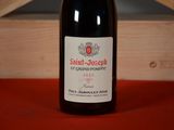 a bottle of wine sitting on a table next to a wooden box
