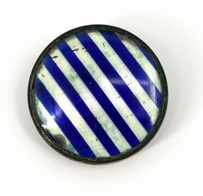 un gros plan d'un bouton rayé bleu et blanc sur une surface blanche