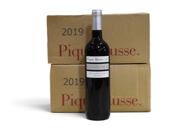 La bouteille de vin est posée à côté de deux cartons de vin.