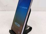 a close up of a cell phone on a stand on a table