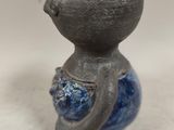 a small vase that has a handle on it