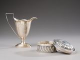 a silver cup next to a silver container on a table