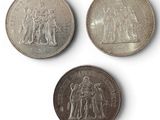 three different british coins are shown on a white surface