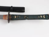 a close up of a knife on a white surface with a black handle