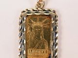 un pendentif en forme de pièce d'or sur lequel est représentée la Statue de la Liberté