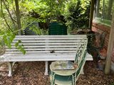 un banc blanc et une chaise verte sous une pergola
