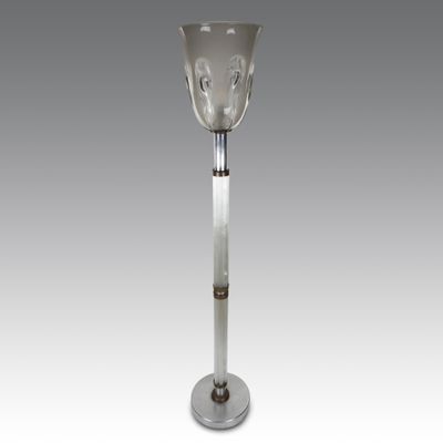 un vase en verre posé sur un socle en métal