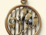 a close up of a pendant with a flower and a bird on it